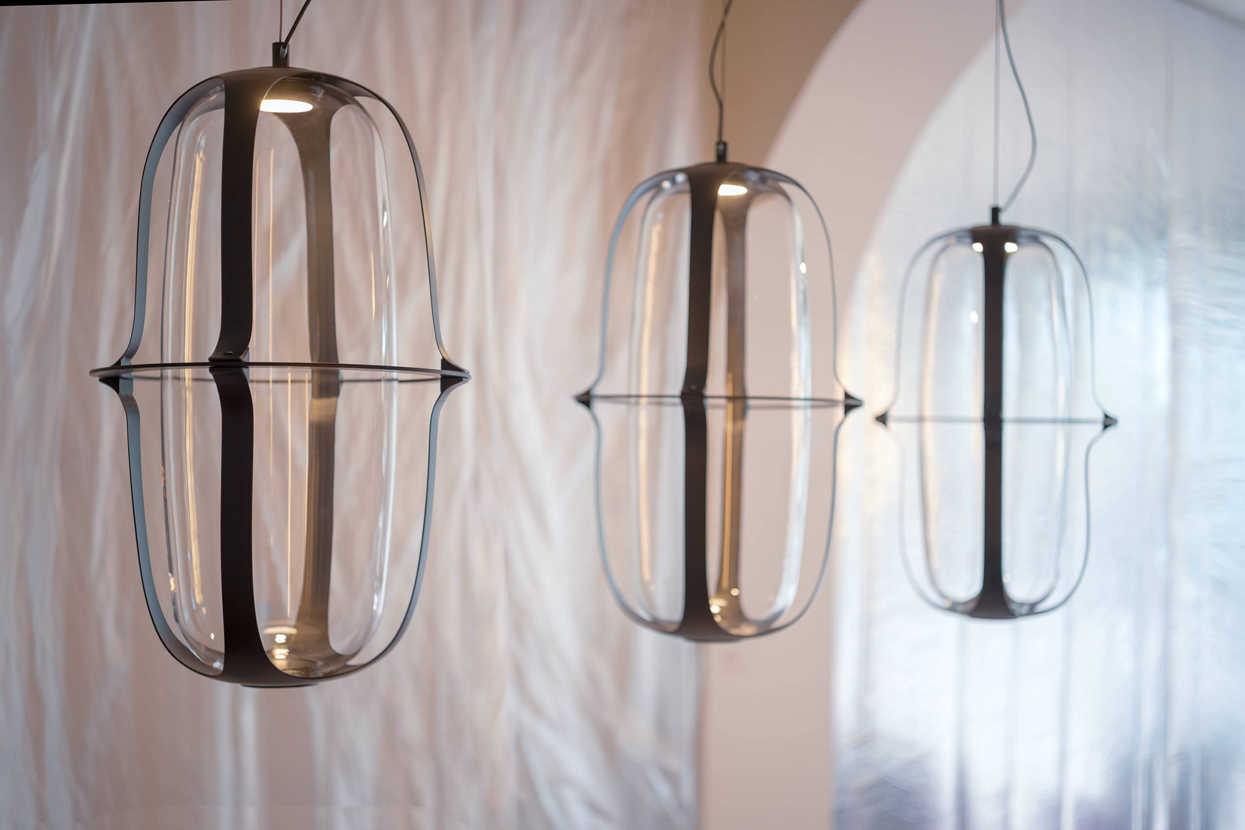 Luci pendenti in vetro trasparente con design moderno e minimalista.