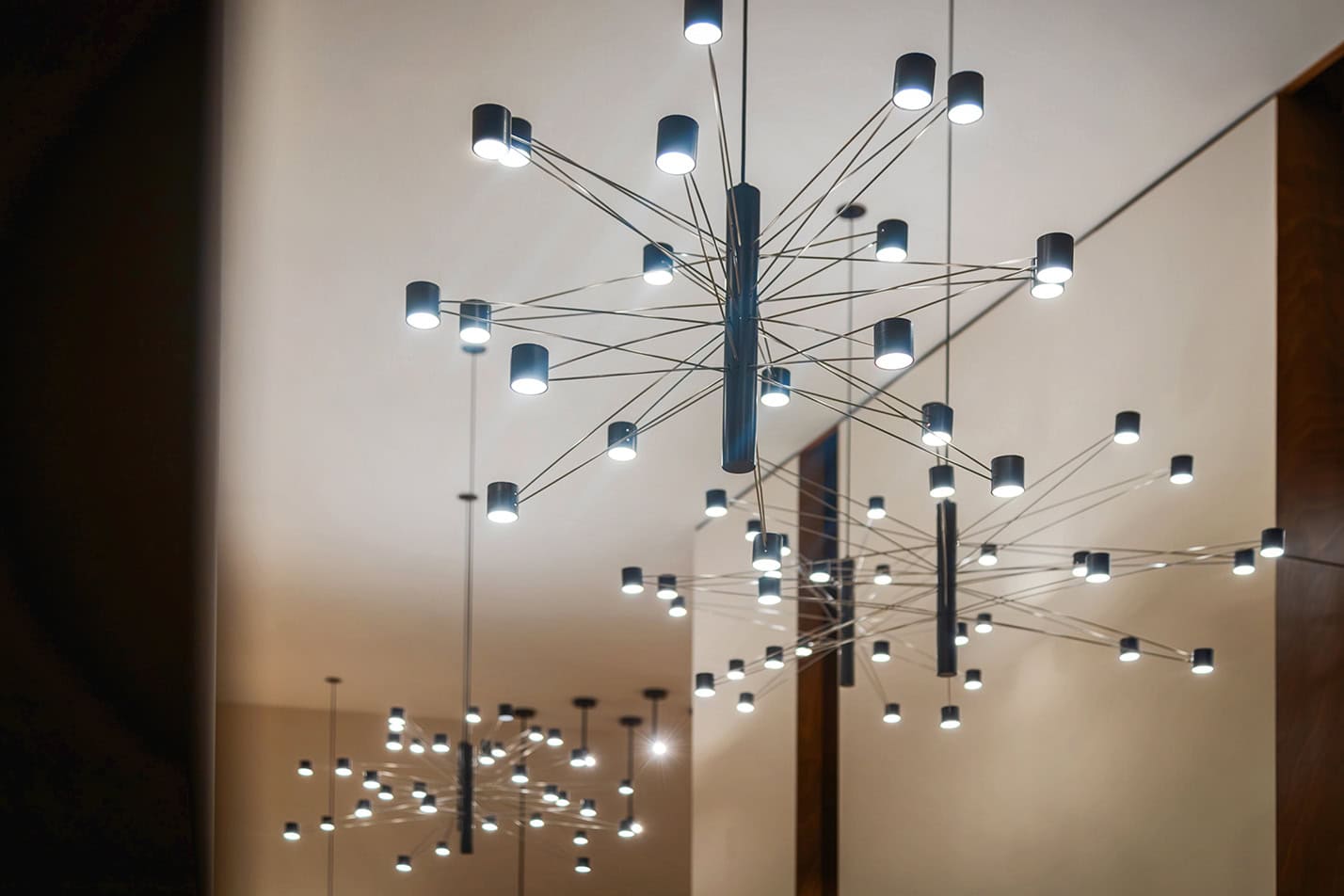 Lampadario moderno con numerosi punti luce a LED, design contemporaneo e materiali innovativi.