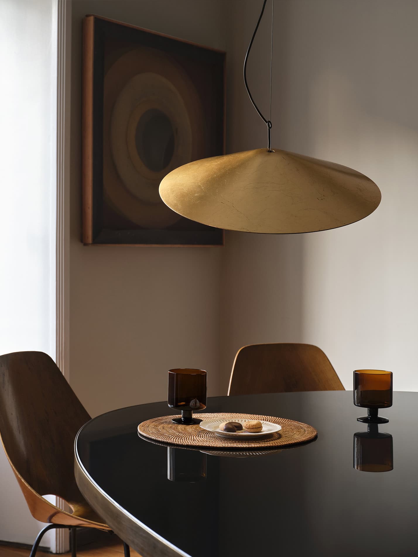 Lampada sospesa in stile moderno sopra tavolo con decorazioni in ceramica.