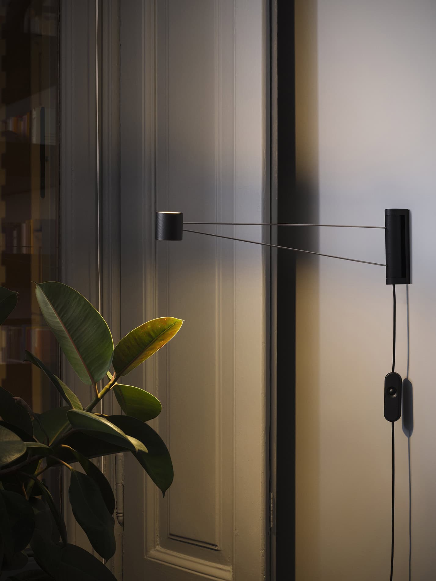 Lampada da parete moderna in stile minimalista con braccio regolabile e finitura nera.